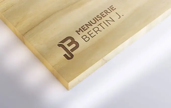 Logo de la Menuiserie Bertin J. gravé sur une planche de bois clair